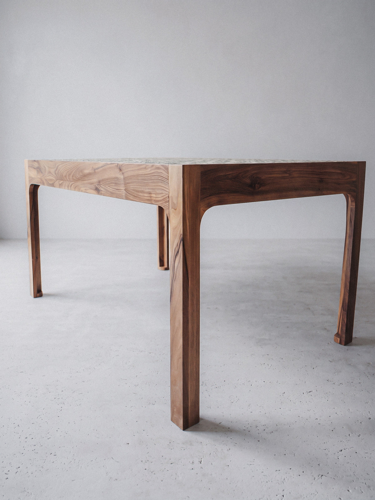 Walnut table with green Tamegrout ceramic top in a contemporary interior
