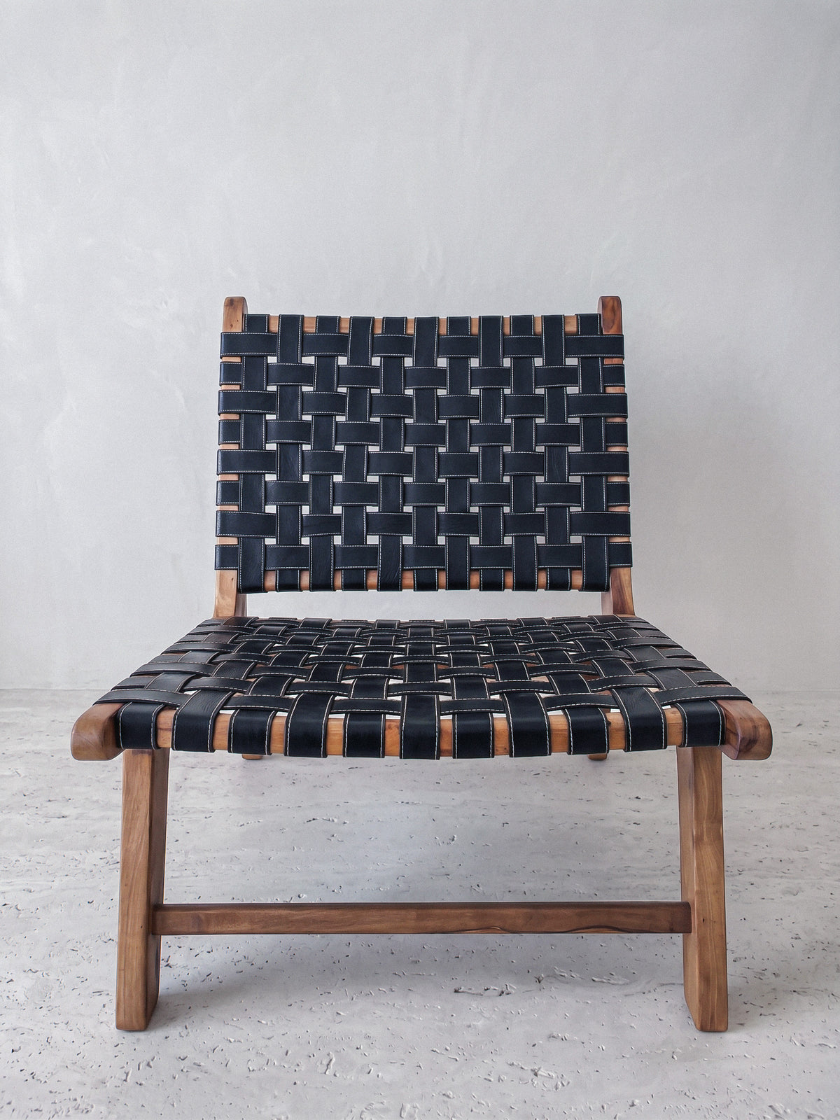Low lounge chair by Casarin, solid walnut frame with woven black saddle leather straps