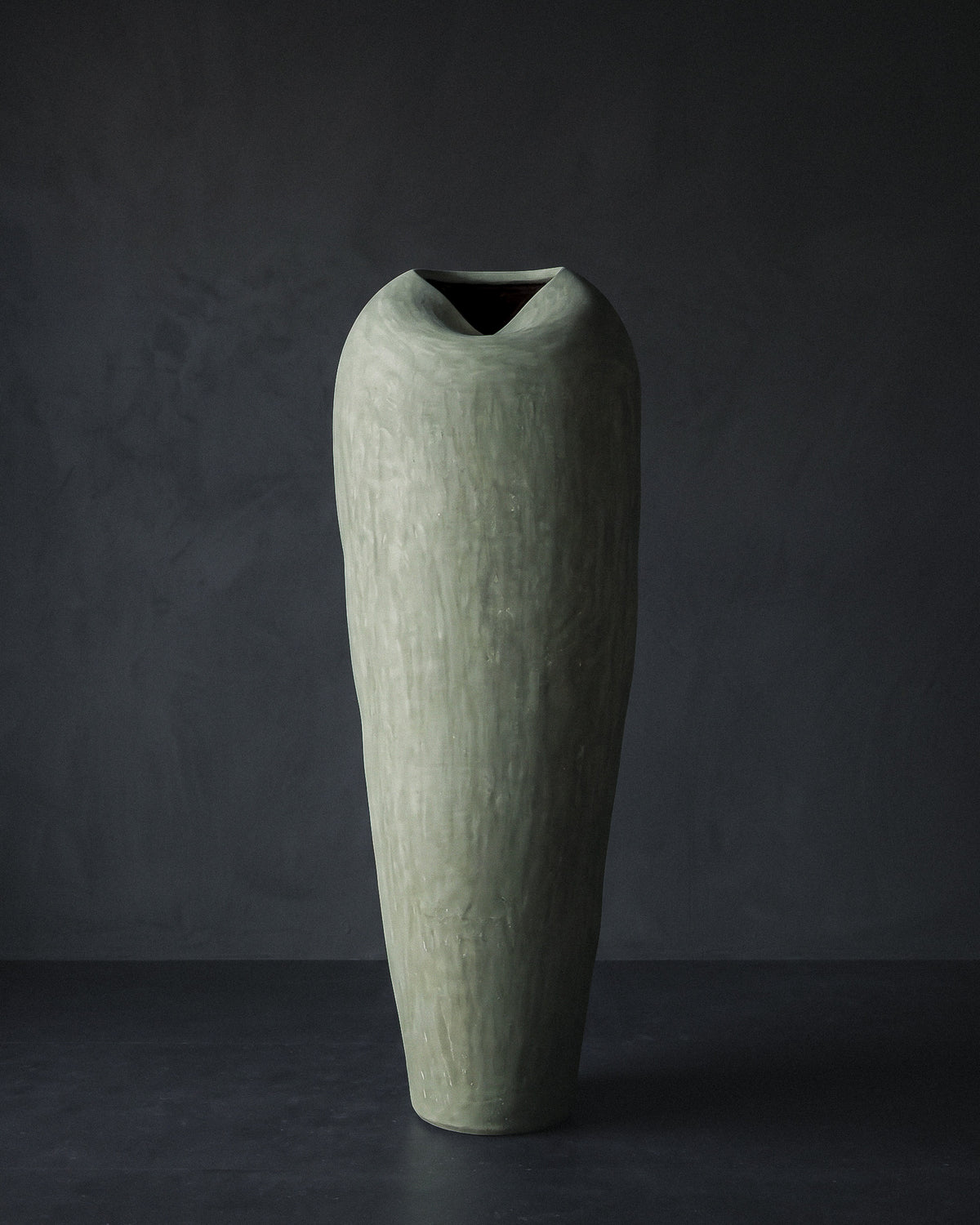 Muted sage tadelakt vessel, side view of the elongated tapered silhouette